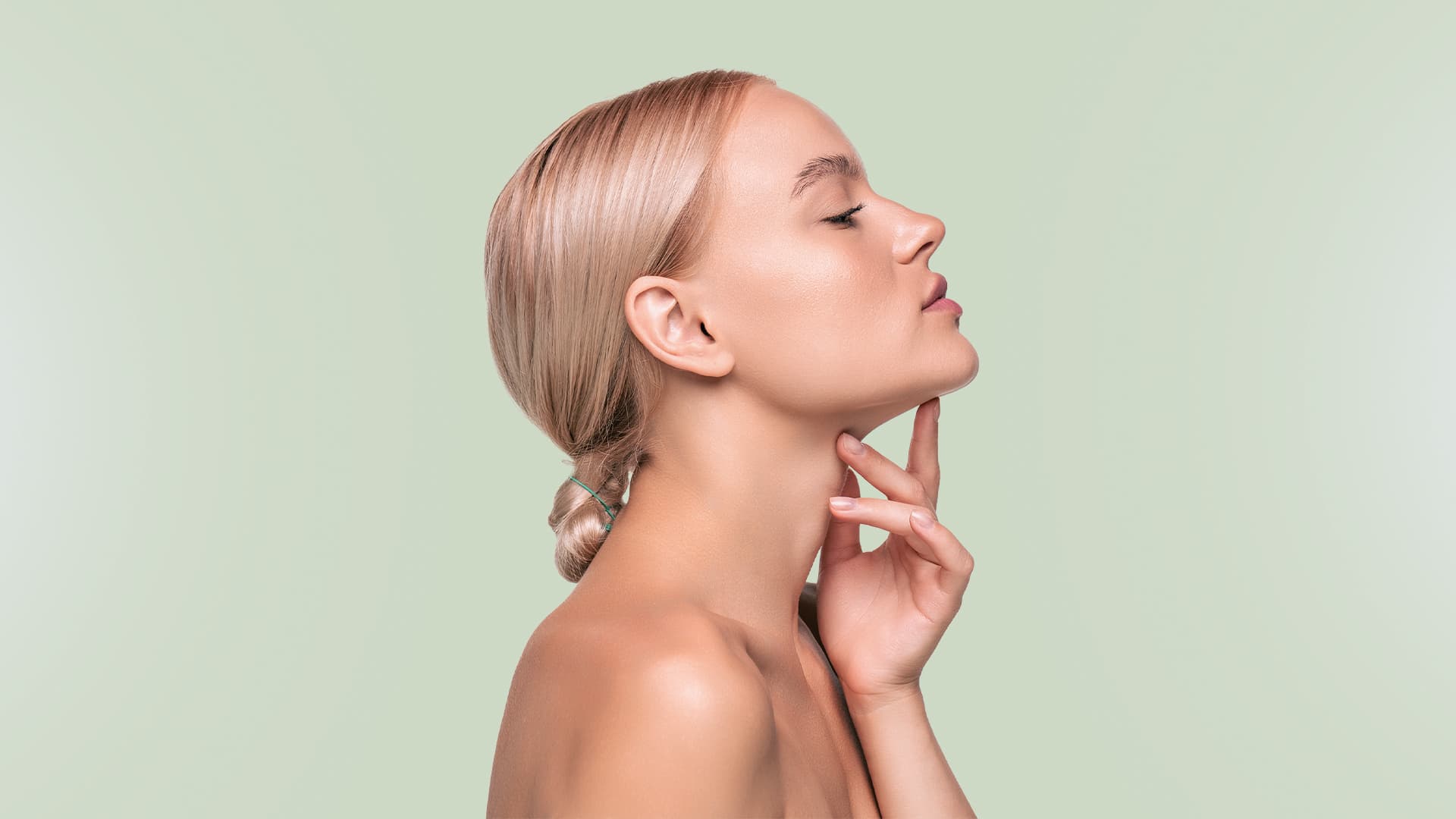 Mulher de perfil com a mão apoiada no queixo