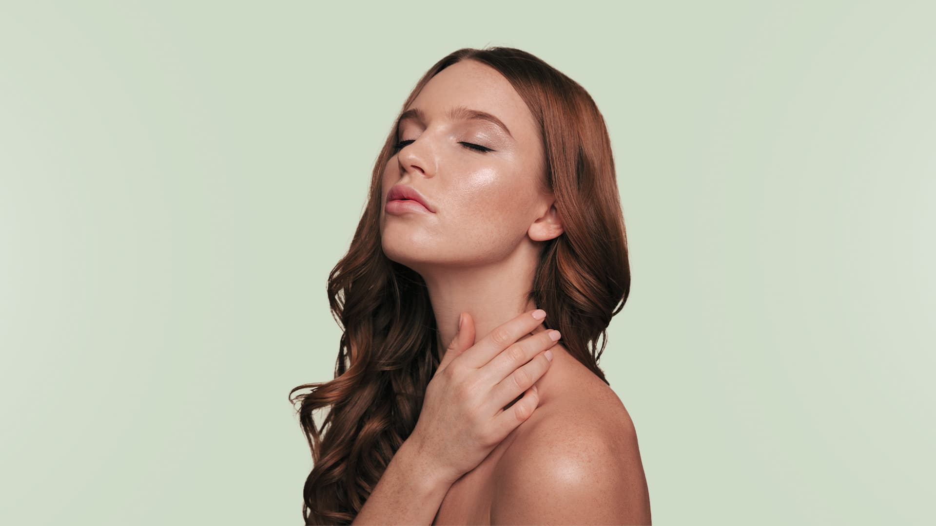Mulher ruiva com os olhos fechados, tocando o ombro